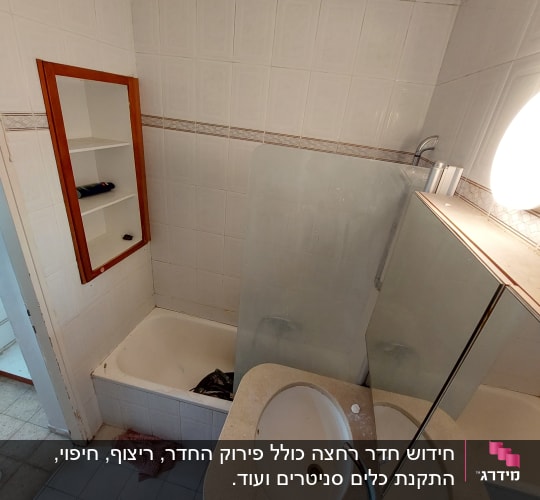 חדר אמבטיה עם כיור, מראה ואמבטיה בתהליך שיפוץ